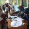 TENANG. Petugas mendata anak sekolah yang akan menjalani vaksinasi Covid-19 di salah satu sekolah dasar di Kabupaten Majalengka, Kamis (13/1).