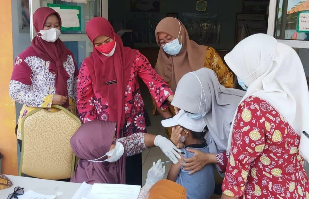 HARI PERTAMA. Program vaksinasi untuk anak-anak usia 6-11 tahun di SDN Margadadi VI di Kecamatan Indramayu berjalan lancar. Tampak orang tua mendampingi anak-anaknya untuk disuntik vaksin.