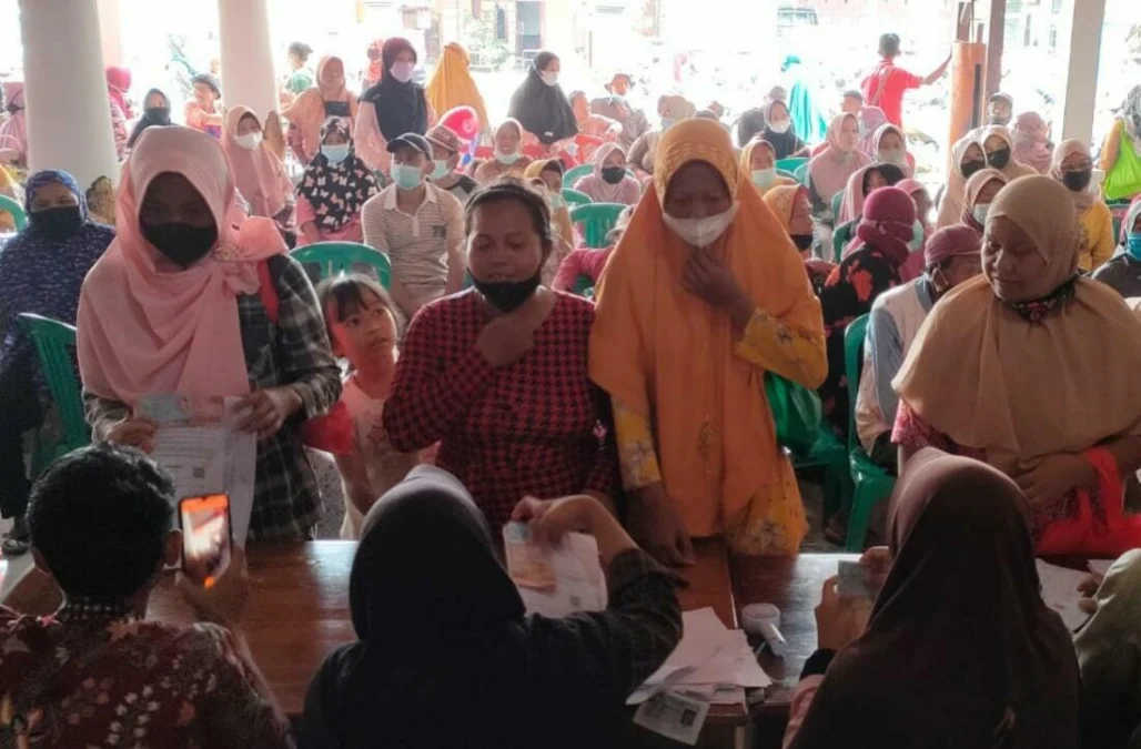 ANTRE. Sejumlah warga antre untuk mendapatkan Bantuan Sosial Tunai di Desa Jatimulya Kecamatan Terisi. Penerima bantuan diwajibkan menunjukkan sertifikat vaksinasi dosis kedua.