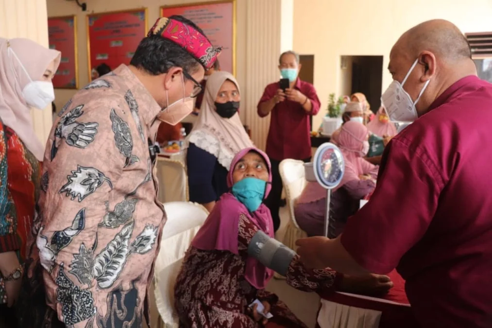 BERBINCANG. Bupati Cirebon, H Imron berbincang dengan salah satu warga yang mengikuti pengobatan gratis yang dilakukan secara massal.
