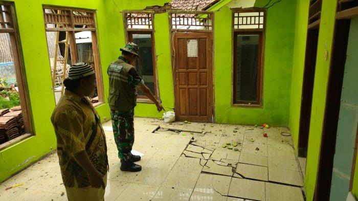 BAHAYA. Petugas menunjukkan kondisi rumah di blok Cigobang Desa Padarek, kecamatan Lemahsugih yang retak-retak akibat pergerakan tanah, Kamis (31/3).